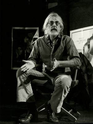 Photographic Materials depicts: white haired man talking while sitting in a director's chair