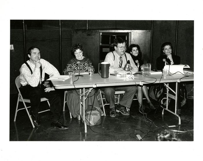 Photographic Materials depicts: Five people with microphones at a table.