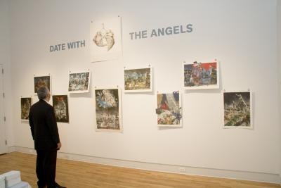 Digital Files, Photographic Materials depicts: Person looking at hung artworks at opening reception