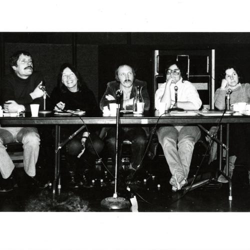 Photographic Materials depicts: black and white photograph of full panel at table with microphones