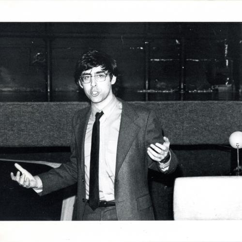 Photographic Materials depicts: black and white photograph of david shapiro lecturing in front of a podium