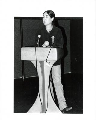 Photographic Materials depicts: black and white photo of Waldman on stage behind a lectern