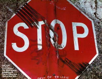 Posters depicts: A beat up stop sign with graffiti and tire tracks on it laying on top of gravel.