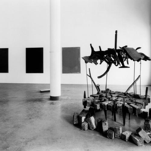 Photographic Materials depicts: black-and-white photographic prints of artworks installed in a gallery